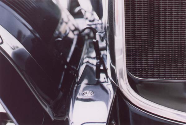 This view provides a strange reflection in the front fender. Note the radiator shell. The bottom inset was painted with pyroxyline lacquer providing a moderate gloss. The unpainted area was protected from paint with a shield or "mask" leaving a finely feathered edge. The second step recess that encircles the opening was unbuffed stainless steel.