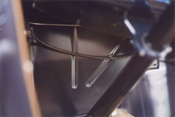 A closer view shows part of the routing of the seamed steel vacuum line and cowl lamp harness conduit. The vacuum line was changed slightly with indented firewalls introduced in May 1931. On those models the line dropped down in the center and passed through the wiring clip behind the terminal box.