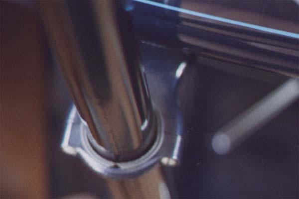 This is a blurry attempt at showing the steering column support anti-rattler (rubber). It shows the angled ends. Unfortunately, less evident is the raised mould line near the column that also shows fibers from the cloth reinforcement within the rubber. Also note the original cadmium plated screws (original plating).