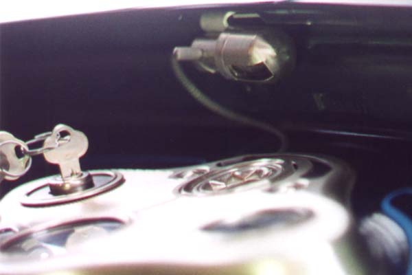 The instrument panel lamp was nickel plated over unbuffed brass on both the base and the cover. The mounting bracket was cadmium plated prior to assembly to the lamp base. The spiral armor on the wire was less closely wound than the modern version. This left a small area of the underlying insulation visible between each spiral.