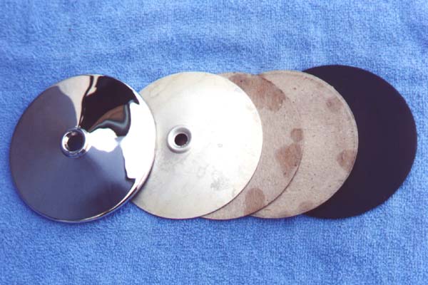 The cadmium plated insert not only backed and supported the thin brass housing shell, but provided a slight spring load against the mirror so it wouldn't rattle in the housing. The two cardboards were used as shims to space the glass outward as well as provide a pad over the cadmium plated insert. The mirror housing had to be opened slightly for removal of the glass. I removed a couple of small dents from the housing, buffed the brass to a "mirror" finish and had it chromed. The glass was resilvered and reinstalled. A friend made a die for reforming the crimped edge around the glass.
